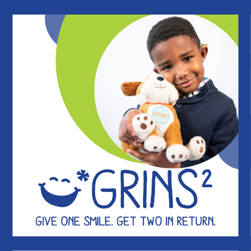 Grins2. Give one smile. Get two in return. Child holding plush dog.